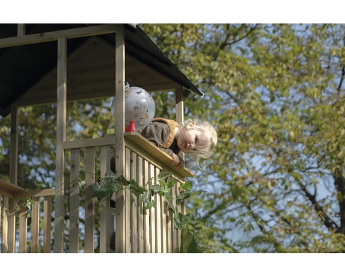 Enfant regardant depuis une cabane en bois avec décoration