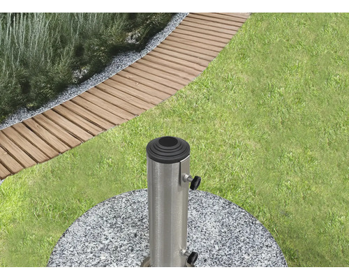 Scène de jardin avec pelouse, dalles de passage et un pied de parasol en granit et métal.