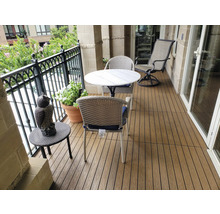 Balkonszene mit Terrassendielen, Tisch, Stühlen und Dekoration