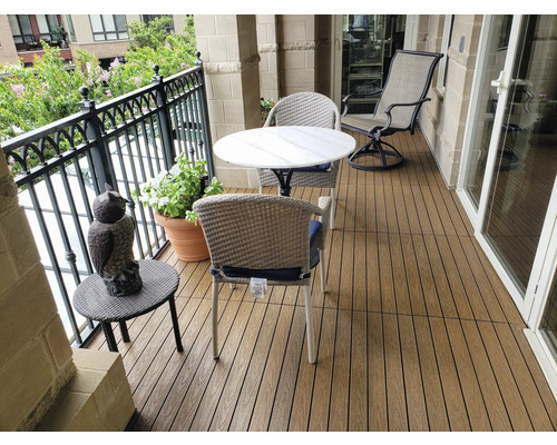 Balkonszene mit Terrassendielen, Tisch, Stühlen und Dekoration