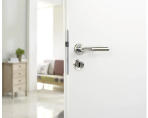 Porte intérieure blanche avec garniture de porte en acier inoxydable dans une pièce lumineuse