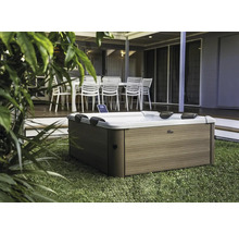 Jacuzzi d''extérieur sur pelouse devant une terrasse avec mobilier de jardin