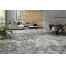 Heller Wohnraum mit Sofa, Esstisch und grau gemusterter Bodenfliese.