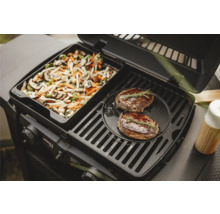 Gasgrill mit Gemüsepfanne und zwei Steaks auf dem Grillrost