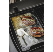 Zwei Steaks mit Rosmarin und Knoblauch auf einer Grillplatte