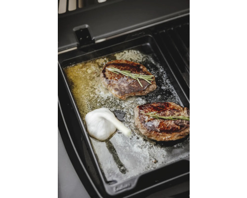 Zwei Steaks mit Rosmarin und Knoblauch auf einer Grillplatte