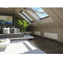 Chambre mansardée lumineuse avec fenêtres de toit, radiateurs, canapé et décoration