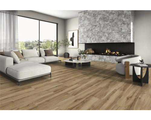 Salon avec canapé, fauteuil, cheminée et carrelage imitation bois pour une ambiance lumineuse et spacieuse.