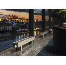 Intérieur avec vue sur une ville de nuit à travers une grande fenêtre et plusieurs radiateurs bancs