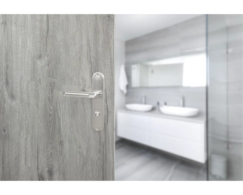 Holztür mit Edelstahl-Türgriff und Badezimmer im Hintergrund