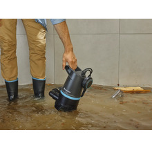 Mann mit Gardena Schmutzwasserpumpe in überflutetem Raum.