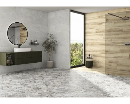 Salle de bain moderne avec lavabo, miroir, douche et carrelage gris au sol.