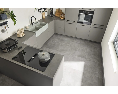 Helle Küche mit Einbauschränken, Spüle, Kochfeld und Fliesenboden.