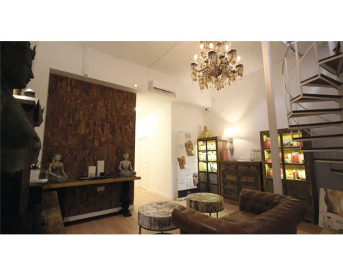 Innenaufnahme eines hellen Raumes mit Möbeln, Dekorationen und einer Wendeltreppe