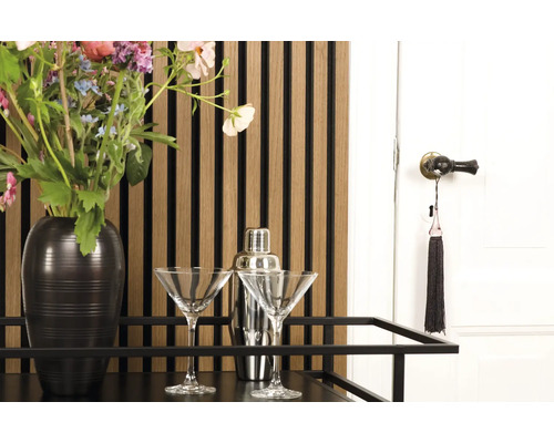 Barwagen mit Blumen, Cocktailgläsern und Shaker vor einer Wandpaneele