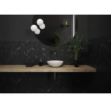 Salle de bain moderne avec carrelage noir en motif chevrons, étagère murale en bois, lavabo à poser et miroir rond