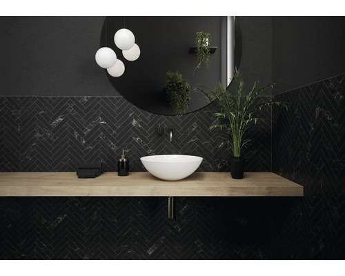Salle de bains moderne avec motif à chevrons noir, lavabo, miroir rond et éclairage