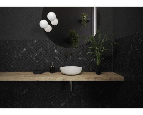 Salle de bains moderne avec motif à chevrons noir, plan de toilette en bois et miroir rond