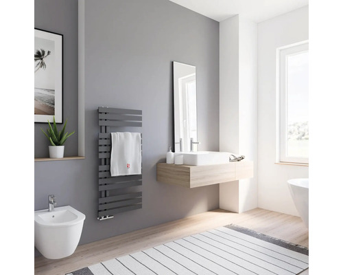 Salle de bains lumineuse avec sèche-serviettes, lavabo, miroir et bidet