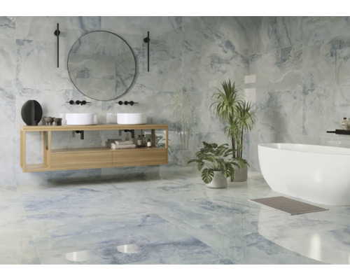 Helles Badezimmer mit Waschbecken, Spiegel, Badewanne und blauen Fliesen