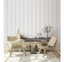 Wohnzimmer mit gestreifter Tapete, Holzsessel und dekorativen Accessoires