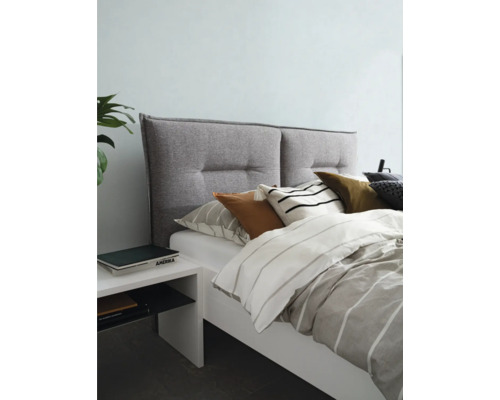 Lit avec tête de lit rembourrée, linge de lit et table de chevet