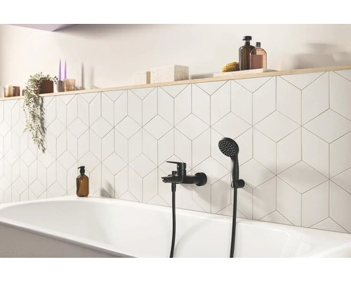 Salle de bains avec baignoire, robinetterie et carrelage géométrique