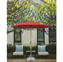 Szene mit einem roten Gartenschirm, zwei Stühlen mit Kissen und einem kleinen Tisch im Freien.