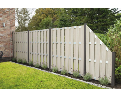 Clôture de jardin composée d''éléments en plastique et de fixations métalliques dans le jardin