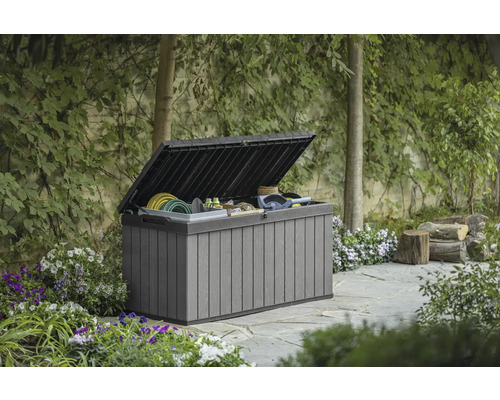 Coffre de jardin ouvert dans le jardin avec des outils de jardinage