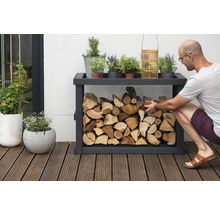 Étagère à bois avec bois et éléments décoratifs à l''extérieur, une personne remplit l''étagère