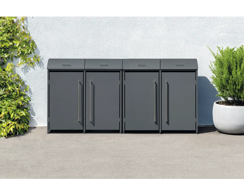 Quatre abris poubelles en métal devant un mur avec des plantes