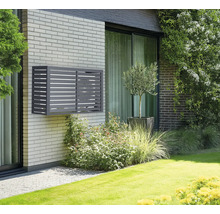 Cache climatiseur gris sur un mur de maison en briques