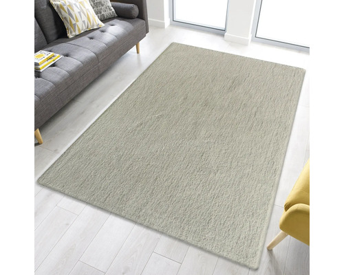 Rechteckiger Teppich im Wohnzimmer neben Sofa und Sessel.