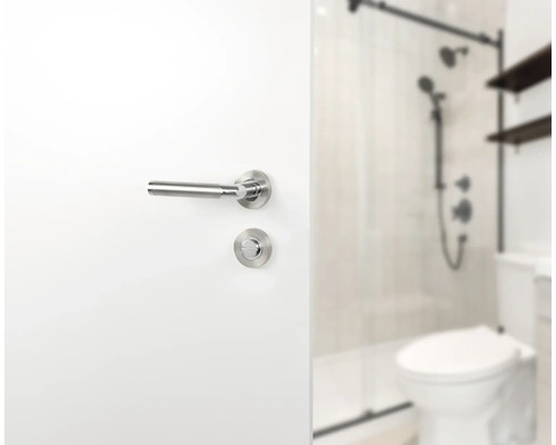 Tür mit Türdrücker und Badezimmer im Hintergrund