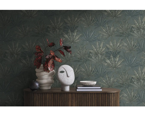 Szene mit einer Kommode, Dekoration und einer Tapete mit Pflanzenmuster.