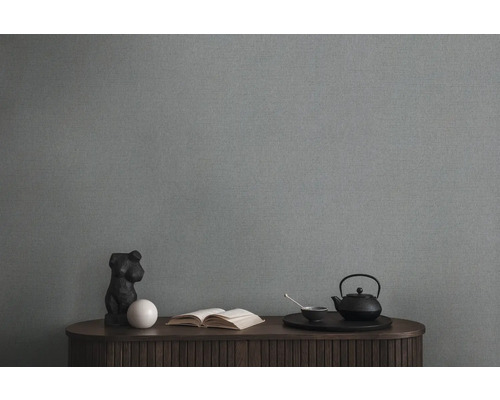 Scène de salon avec papier peint textile gris, commode, livre et service à thé