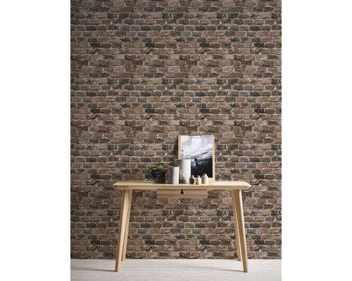 Décoration murale avec papier peint aspect brique et table en bois clair