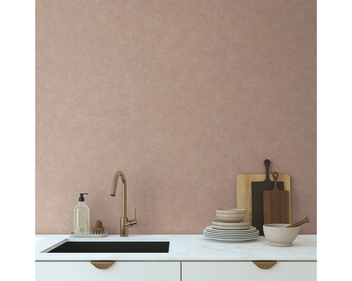 Moderne Küchenszene mit Spüle, Armatur, Geschirr und Schneidebrettern vor einer texturierten Wand