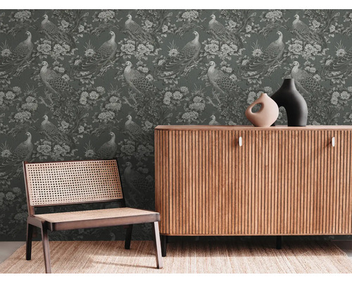 Einrichtungsszene mit Kommode, Stuhl und Tapete mit Pfauenmuster