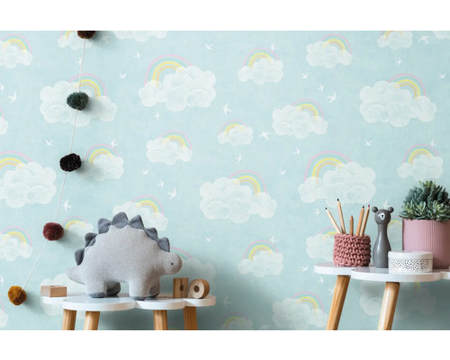 Chambre d''enfant avec papier peint nuages arc-en-ciel, peluche dinosaure et décoration sur une table