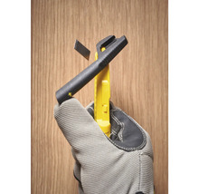 Messerwerkzeug mit Abbrechklinge in Hand mit Arbeitshandschuh vor Holzhintergrund