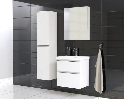 Salle de bain avec lavabo, armoire de toilette et armoire haute devant un revêtement mural en carreaux foncés