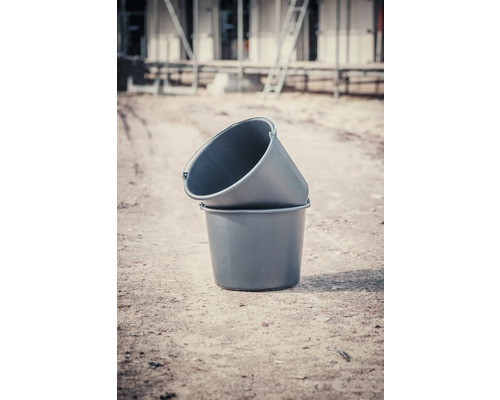 Deux seaux à mortier en plastique empilés l''un sur l''autre sur un chantier.