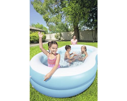 Aufblasbarer Pool mit spielenden Kindern im Garten