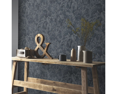 Intérieur avec papier peint à feuilles bleu-gris et table en bois avec décoration