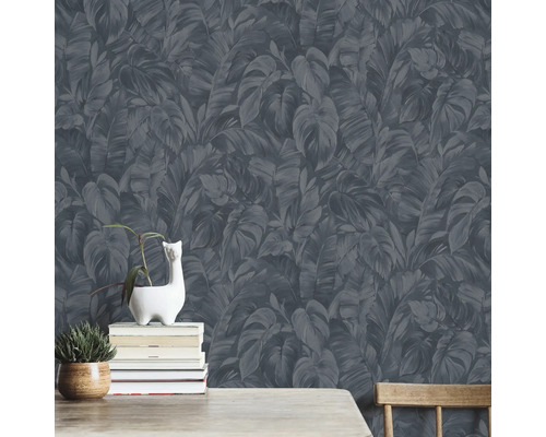 Mur avec papier peint foncé à motifs de feuilles, décoré avec des plantes et des livres.