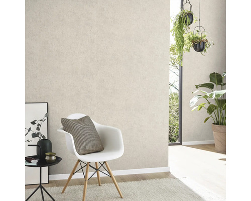 Heller Wohnraum mit hellbeige gemusterter Tapete, Stuhl, Tisch und Pflanzen