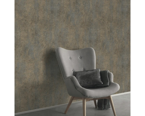 Wandgestaltung mit grauer Vliestapete neben einem Sessel.