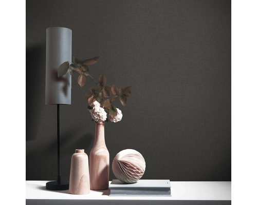 Nahaufnahme einer schwarzen Textiltapete mit dekorativen Elementen wie Lampe, Vase und Buch